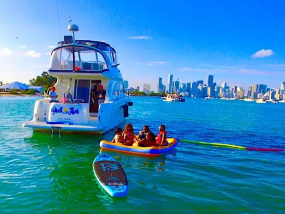 Guests riding water toys behind 45′ Meridian Miami