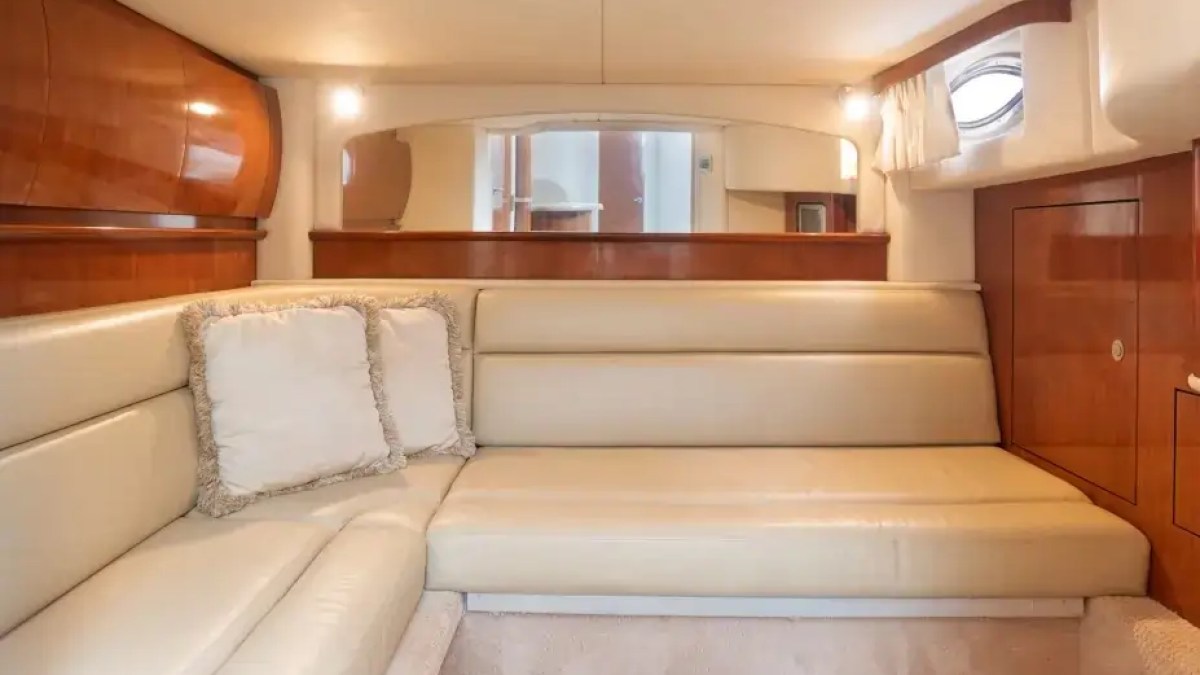 Luxurious yacht interior with beige leather seating and wooden cabinets.