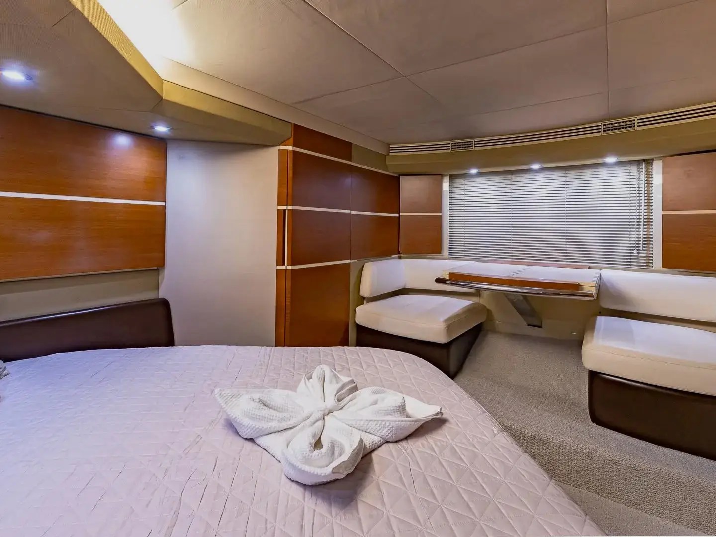 50 Azimut Yacht Charter VIP stateroom featuring king berth, private lounge seating, elegant wood finishes, and luxury overnight accommodations in Miami waters
