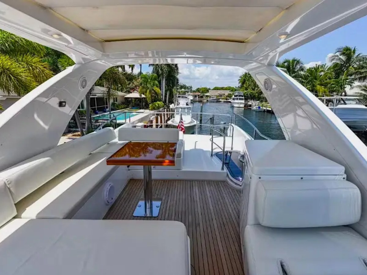 50 Azimut Yacht Charter flybridge lounge featuring wraparound seating, teak decking, dining table, and elevated canal views near Coconut Grove and Coral Gables waterways