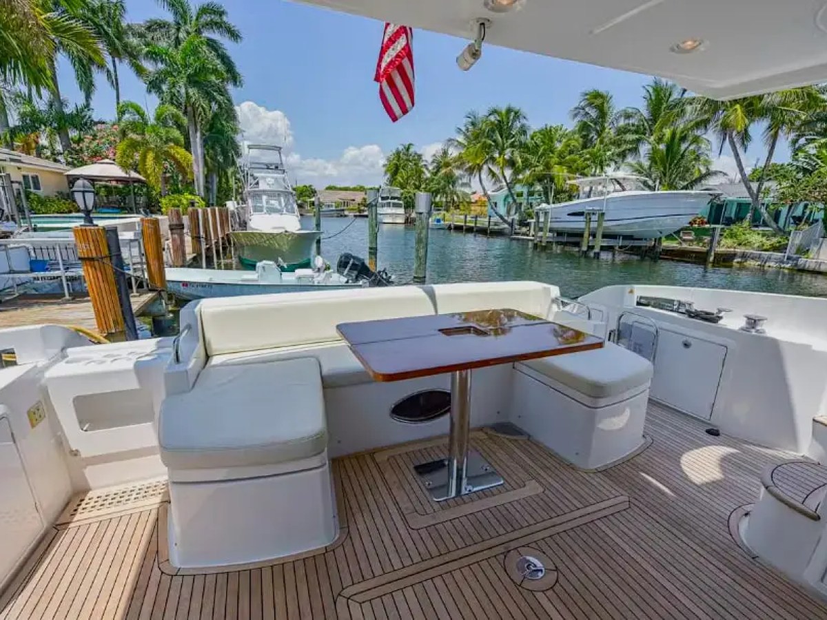 50 Azimut Yacht Charter aft cockpit featuring wraparound seating, teak decking, dining table, and waterfront views along luxury canals near Pinecrest and Coral Gables waterways