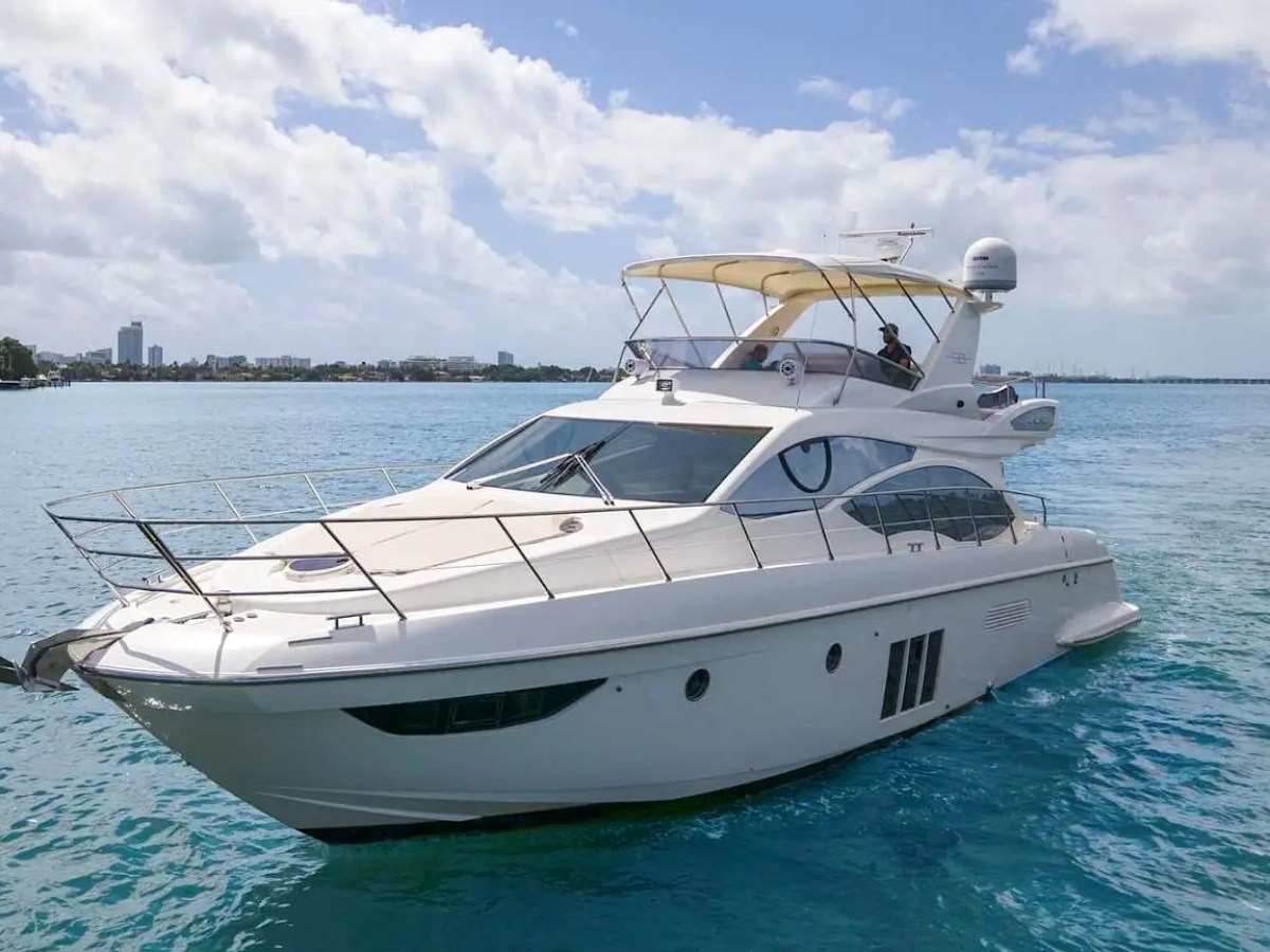 50 Azimut Yacht Charter cruising across Biscayne Bay with a spacious flybridge, sleek bow seating area, and Miami waterfront views under sunny South Florida skies