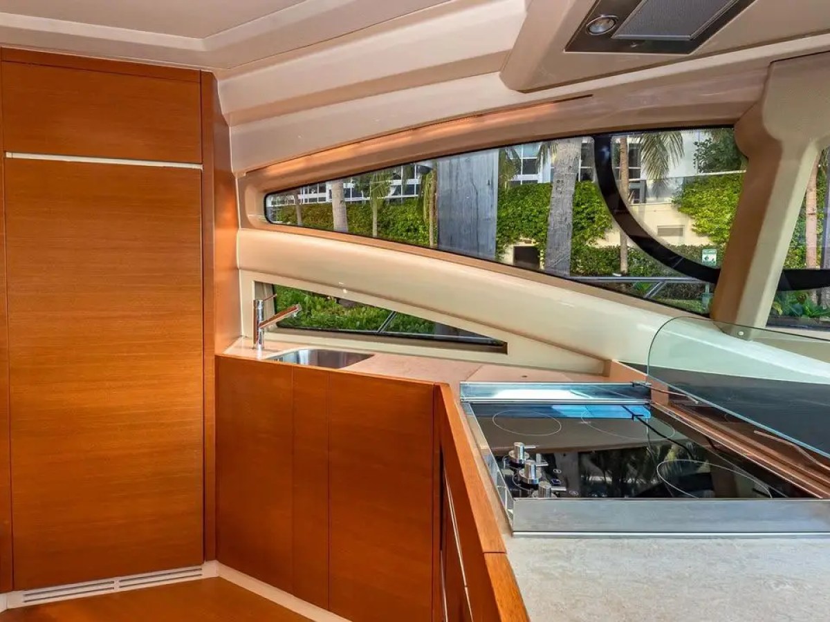 50 Azimut Yacht Charter galley featuring modern cabinetry, integrated cooktop, sink, and panoramic side windows while docked near the Venetian Islands and Miami waterfront