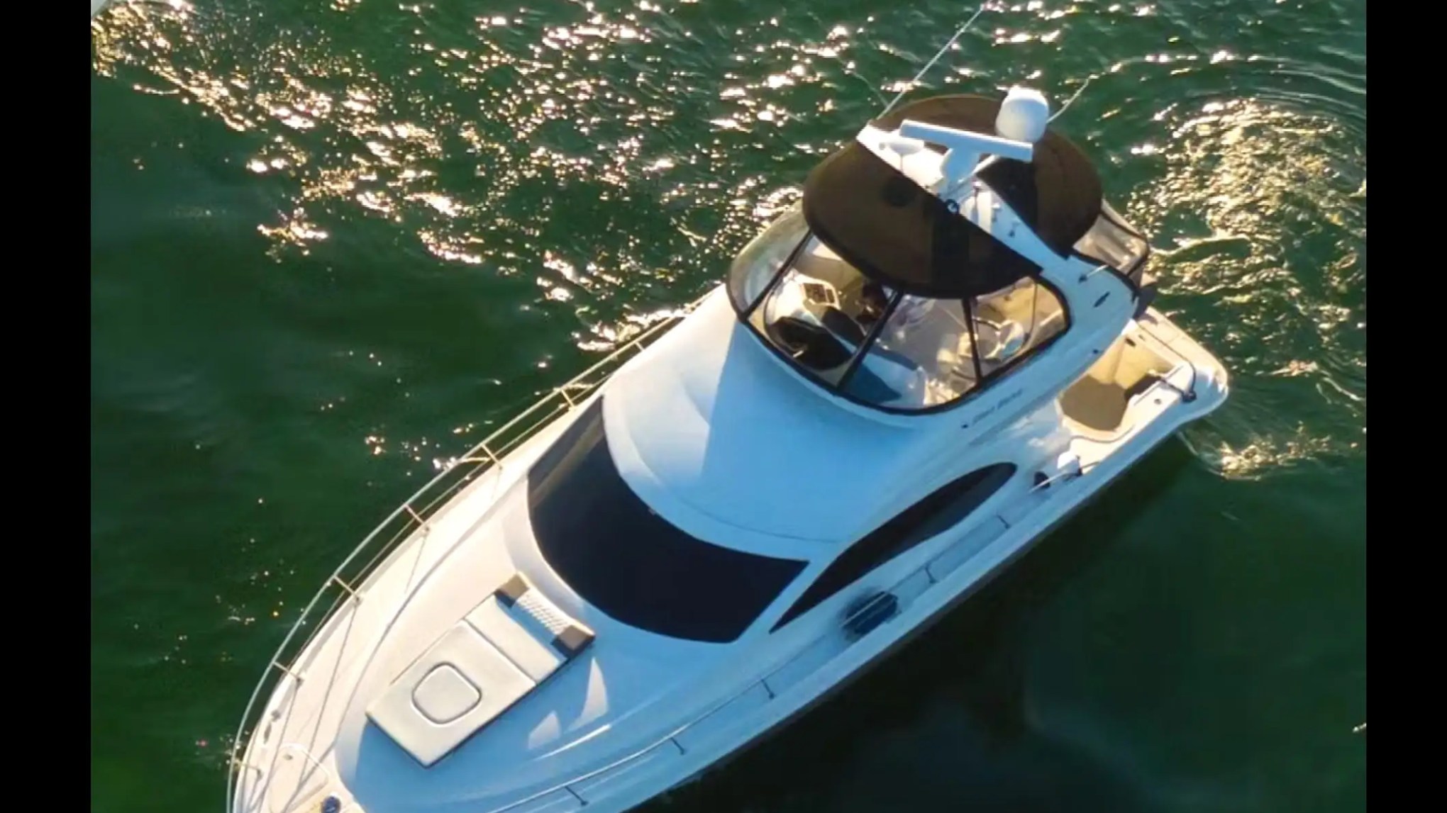 50′ SeaRay yacht top-down cruising near skyline