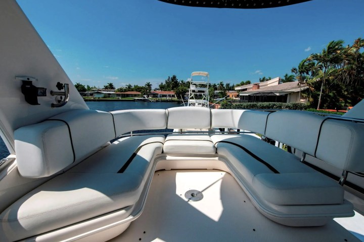 Luxury yacht deck with white cushioned seating and clear sky view.