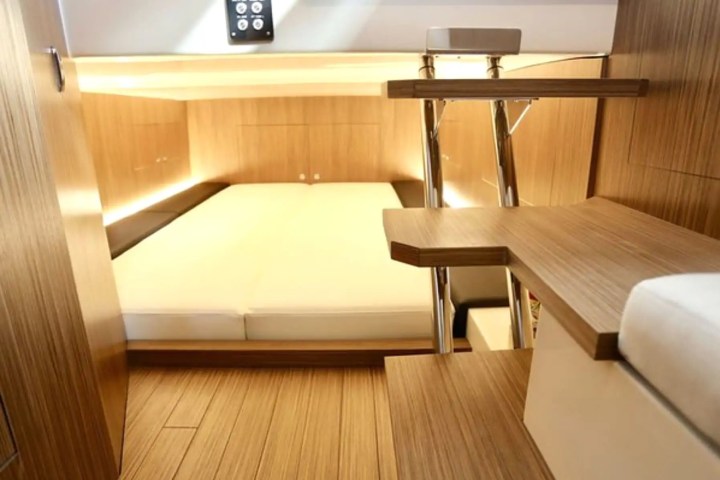 Compact and modern cabin interior with a wooden finish and bed.