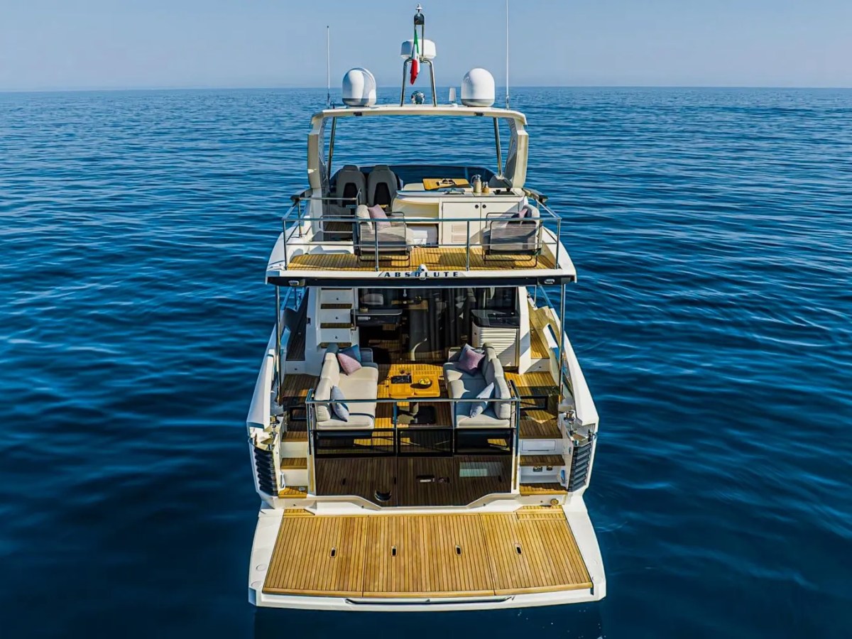52' Absolute Yacht Charter stern aerial view showcasing the expansive swim platform, aft lounge seating, flybridge deck, and open-water cruising near Miami and Biscayne Bay