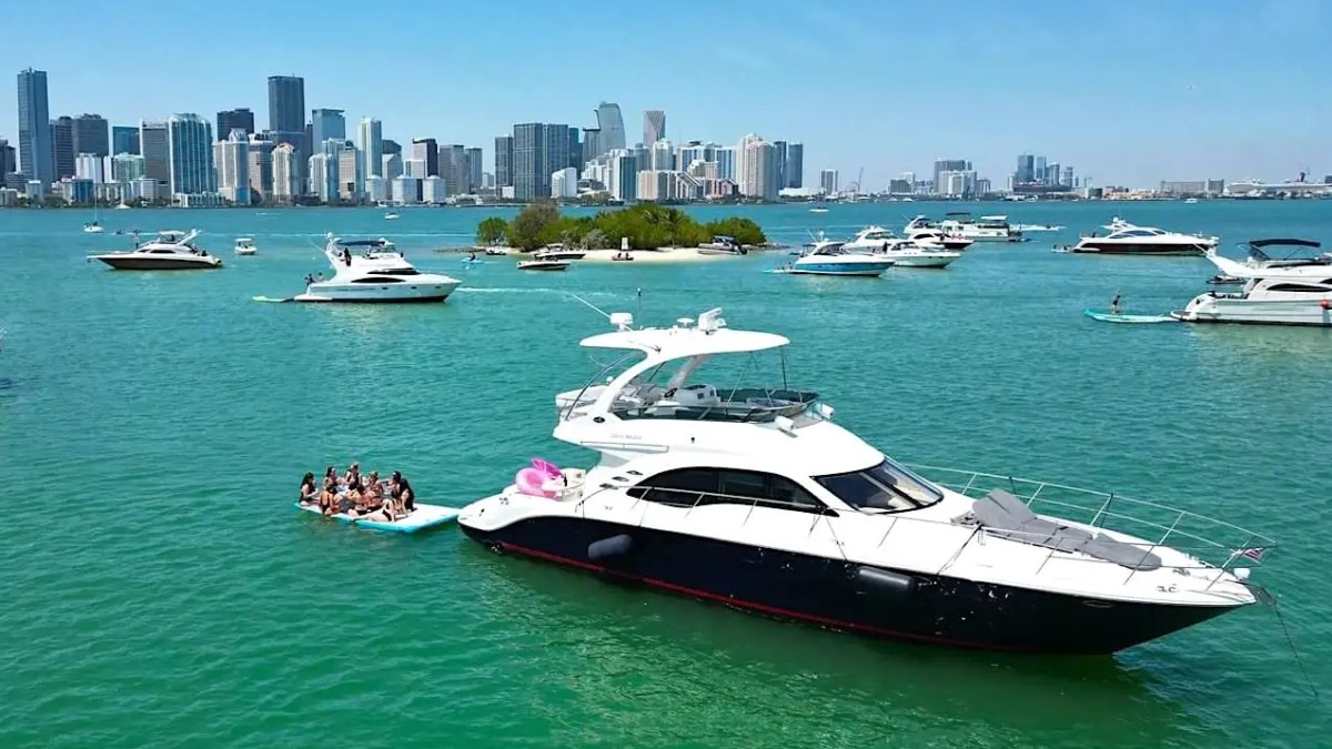 56′ SeaRay yacht anchored with guests playing on water toys in Miami Beach