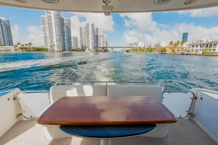 View from boat's deck with table, city skyline and water in background.