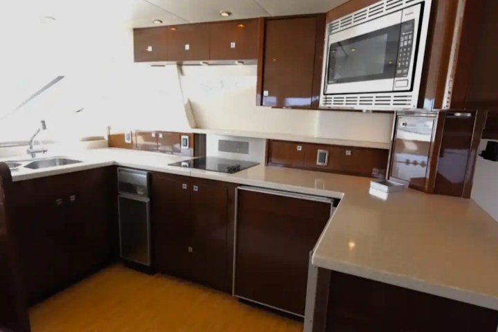 Modern kitchen with dark wood cabinets, microwave, stovetop, and sink.