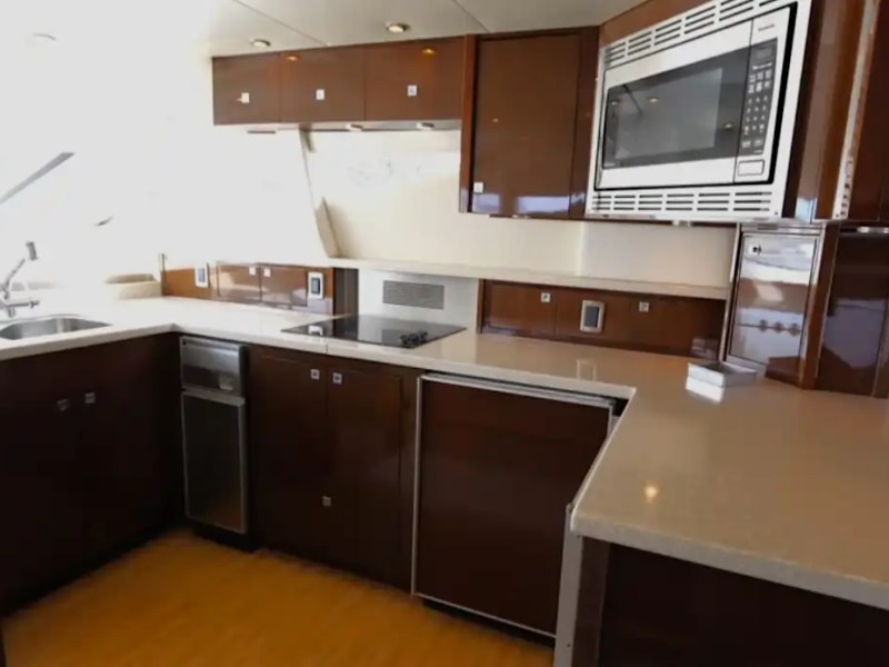 Modern kitchen with dark wood cabinets, microwave, stovetop, and sink.