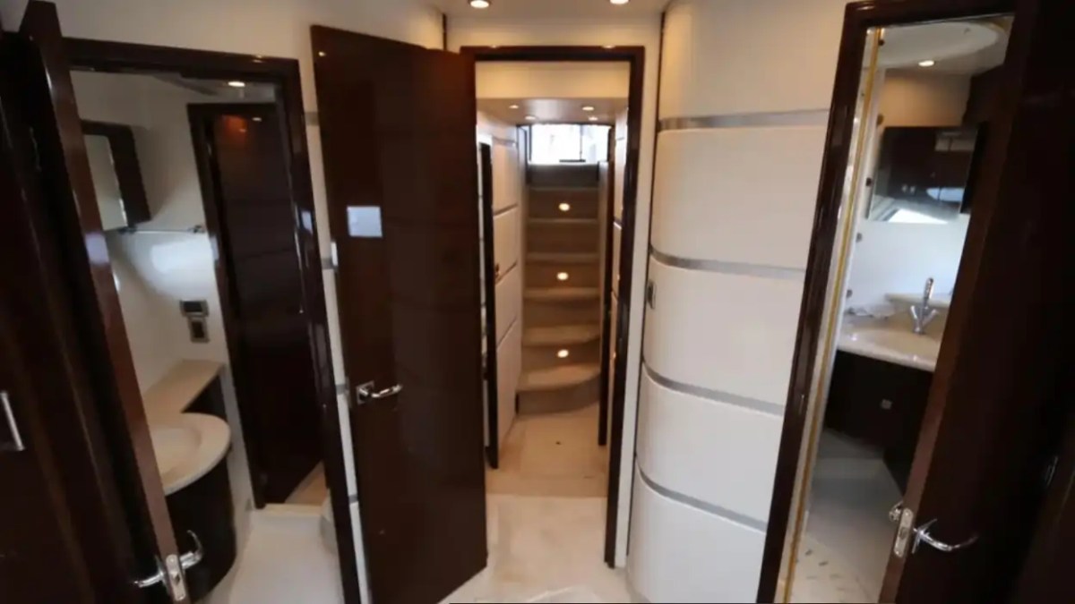 Interior of a yacht with open doors leading to bathrooms and stairs.