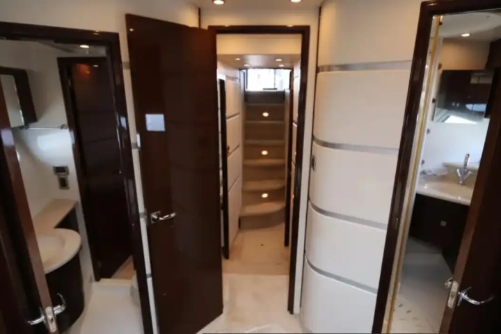 Interior of a yacht with open doors leading to bathrooms and stairs.