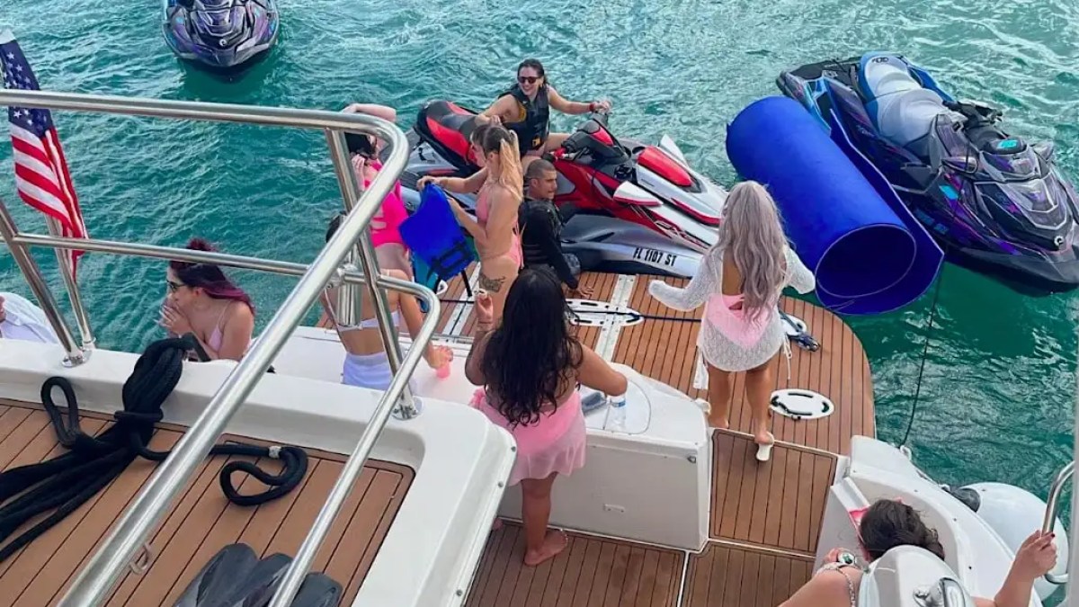 Guests playing with water toys at the swim platform of 58′ SeaRay 2 yacht in Miami Beach