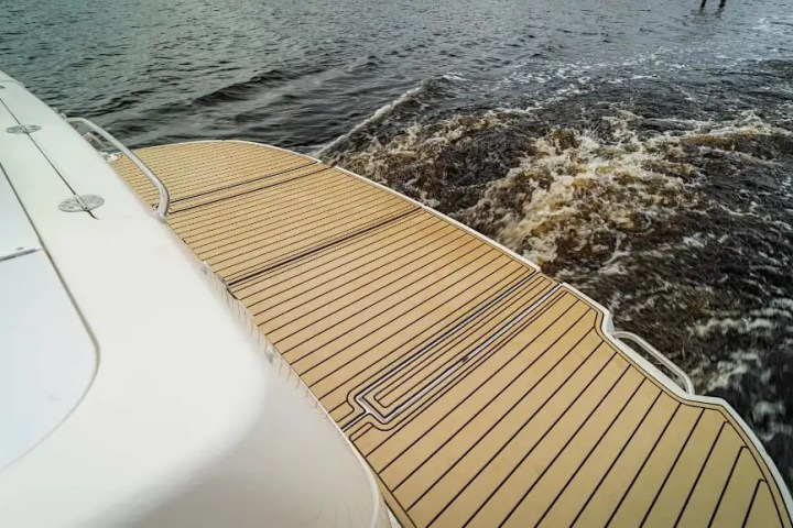 Boat deck with wooden finish, water splashing in the background.