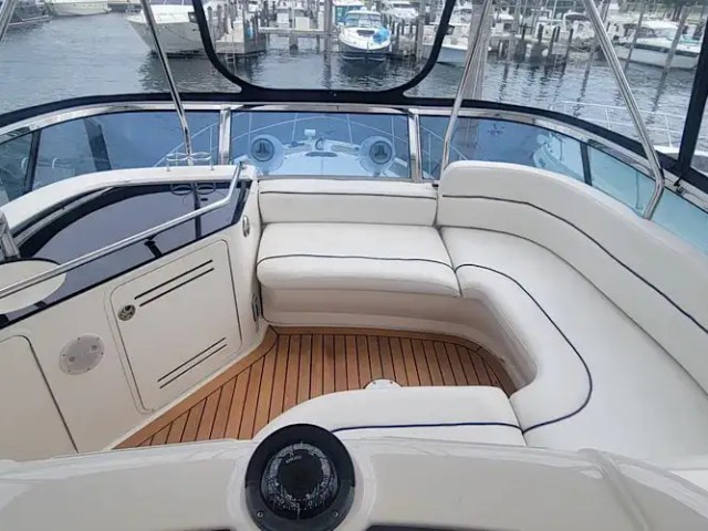 Luxury yacht deck with white seating and wooden floor.