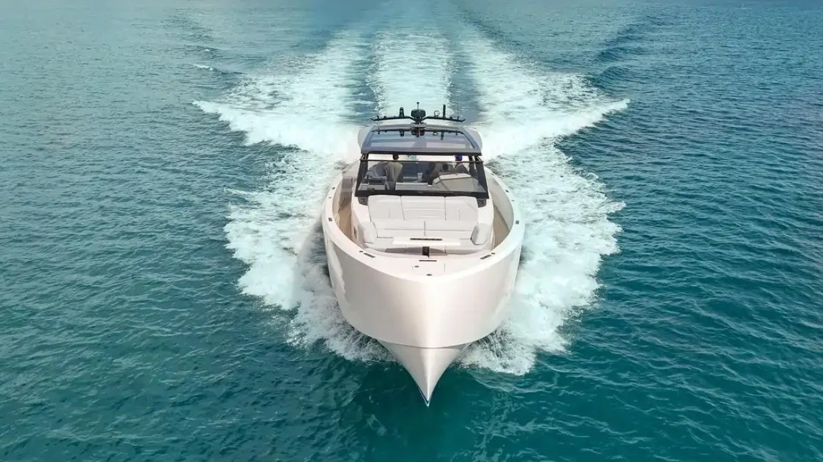 Aerial bow view of a 58 foot Vanquish Yacht Charter cruising across turquoise Palm Beach waters with a sleek modern profile and dynamic wake behind the yacht.