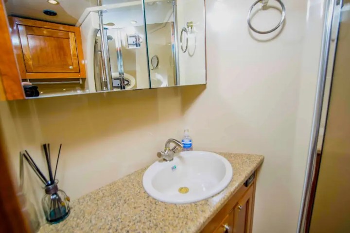 Bathroom with mirror, sink on granite counter, cabinet, and a towel ring on wall.