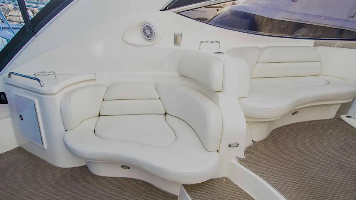 Luxurious boat seating area with white cushioned seats and carpeted flooring.