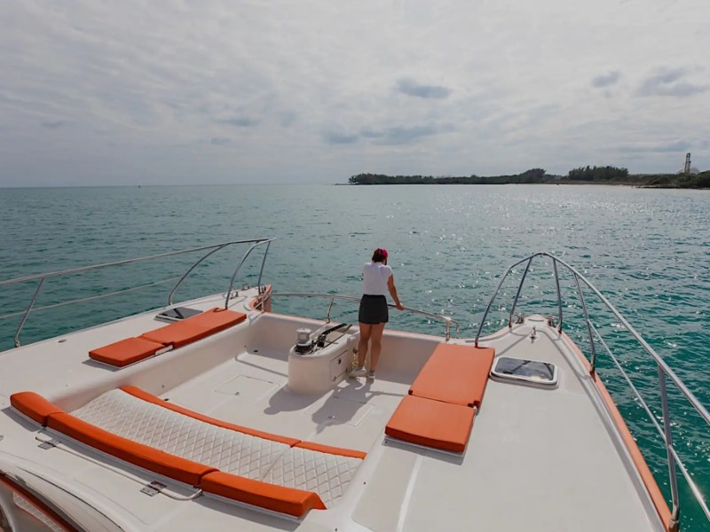 Bow seating with coastline backdrop on 62′ Powercat Miami