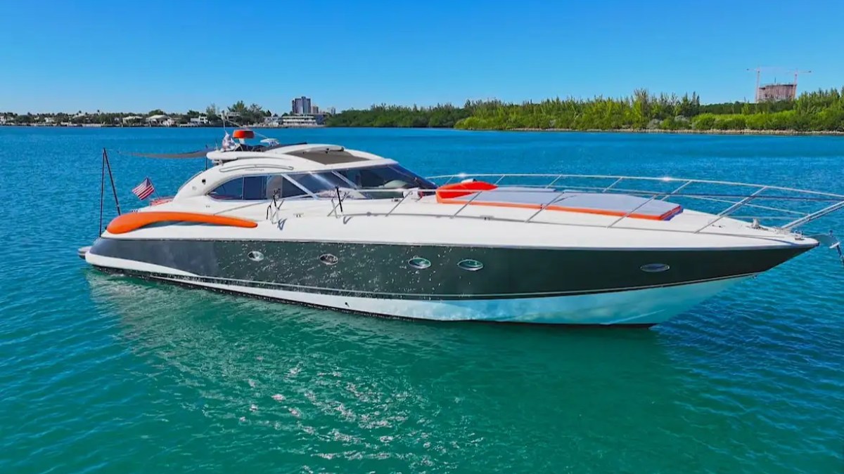 Luxury yacht with orange accents on blue water under a clear sky.
