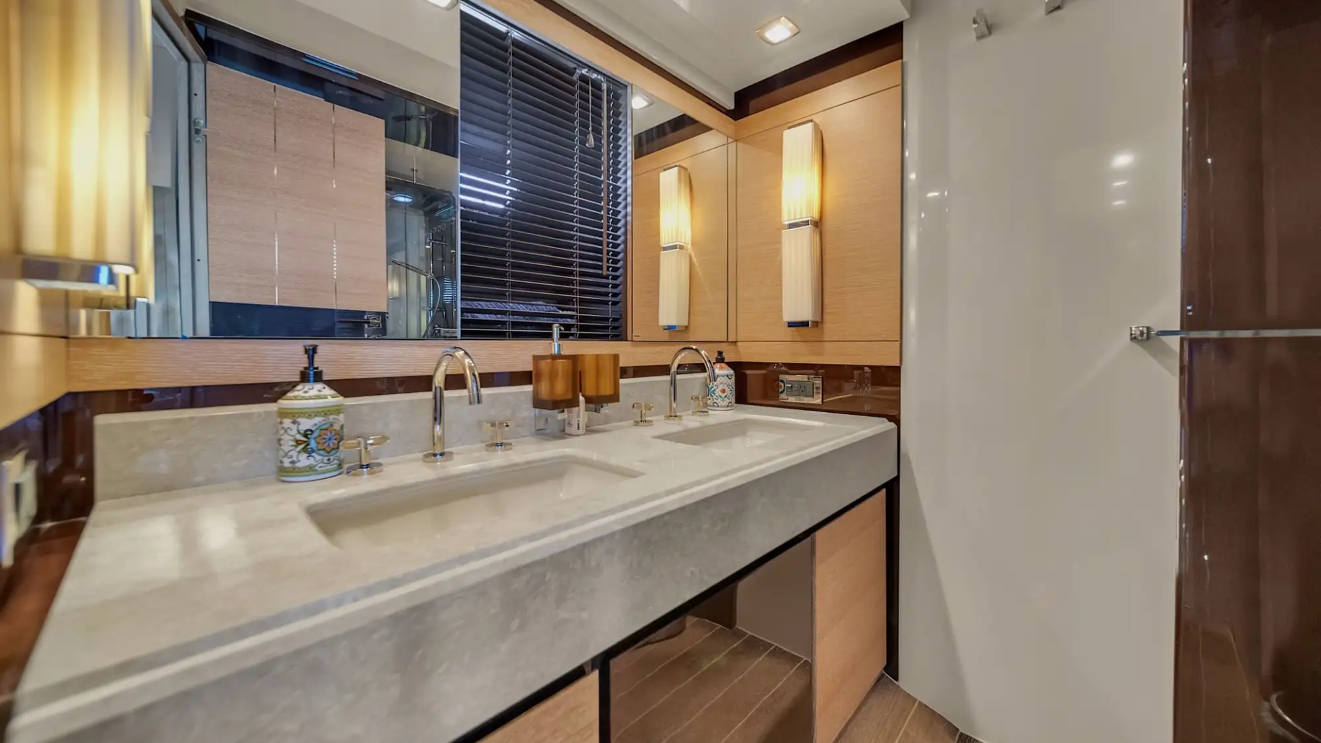 Modern bathroom with double sink, wooden cabinets, large mirror, and decorative lighting.