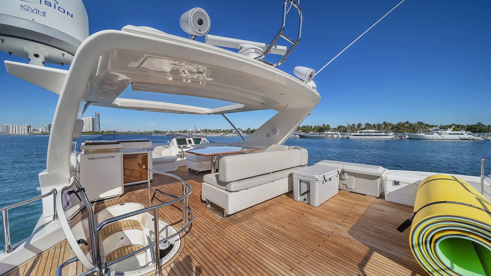 Luxury yacht deck with seating and sea view, clear blue sky.