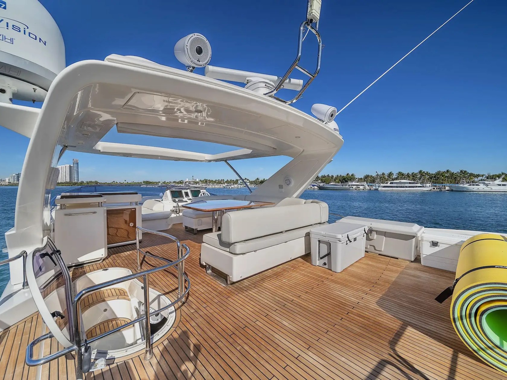 Luxury yacht deck with seating and sea view, clear blue sky.