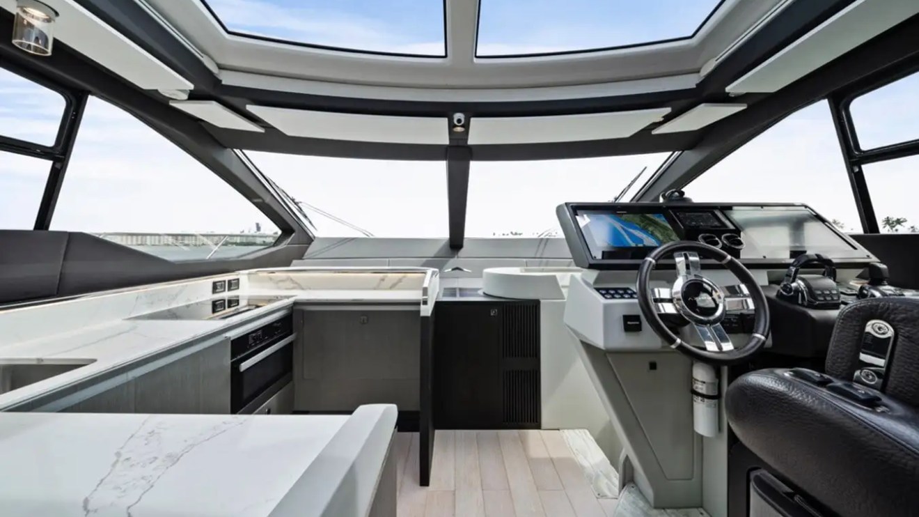 Modern yacht interior with spacious cockpit, navigation controls, and large windows for panoramic views.