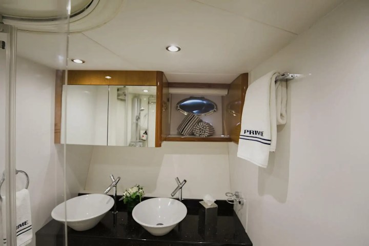 Modern bathroom with double sinks, wall mirror, and towels on rack.