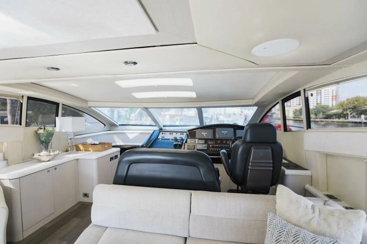 Interior of a luxury yacht with modern helm, windows, and comfortable seating.
