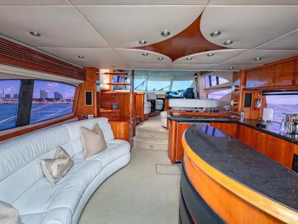Luxurious yacht interior with white leather seating and wood accents.