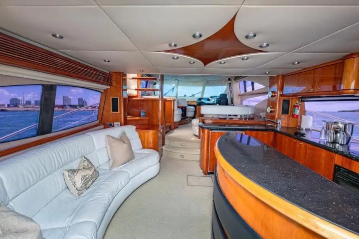 Luxurious yacht interior with white leather seating and wood accents.