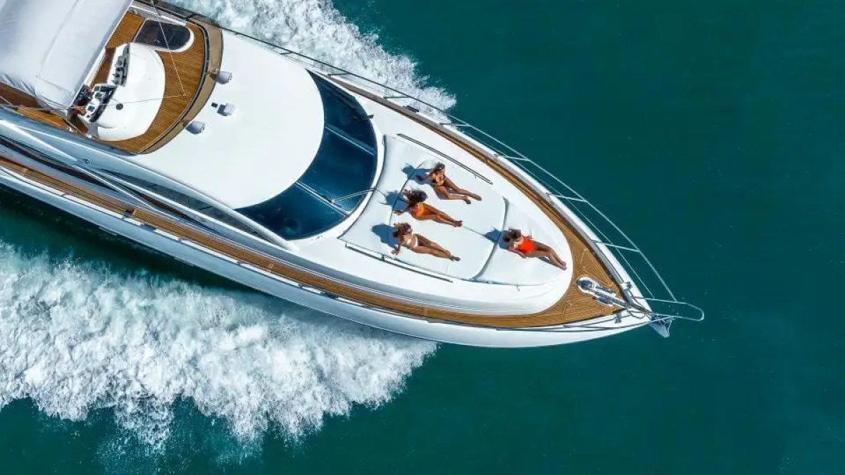Aerial view of a yacht with four people sunbathing on the deck.