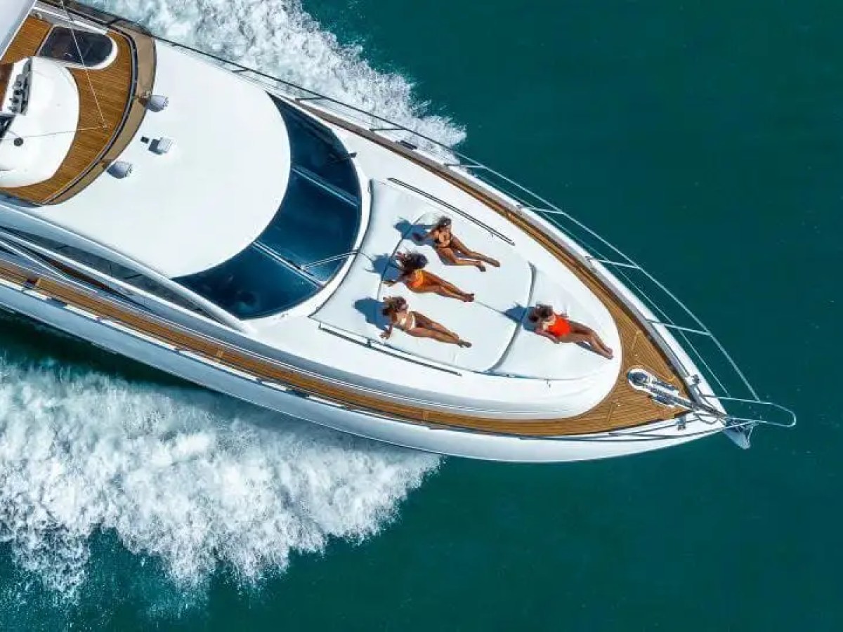 Aerial view of a yacht with four people sunbathing on the deck.