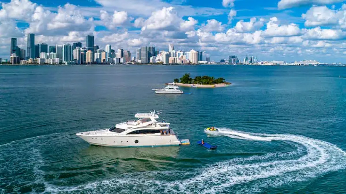 75' Aicon yacht charter with jet ski riding in Miami Beach on Biscayne Bay skyline