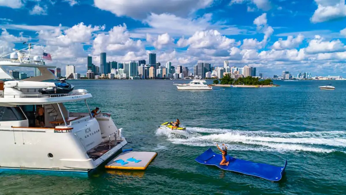 75' Aicon yacht charter guests enjoying jet ski and floating mat in Miami Beach Biscayne Bay