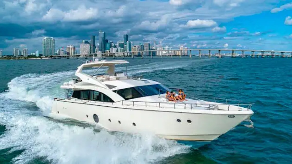 75' Aicon yacht charter cruising Miami skyline Biscayne Bay with guests on bow