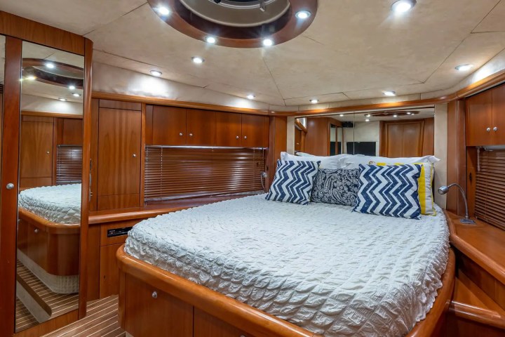 Luxurious boat cabin with a bed, wooden paneling, and decorative pillows.