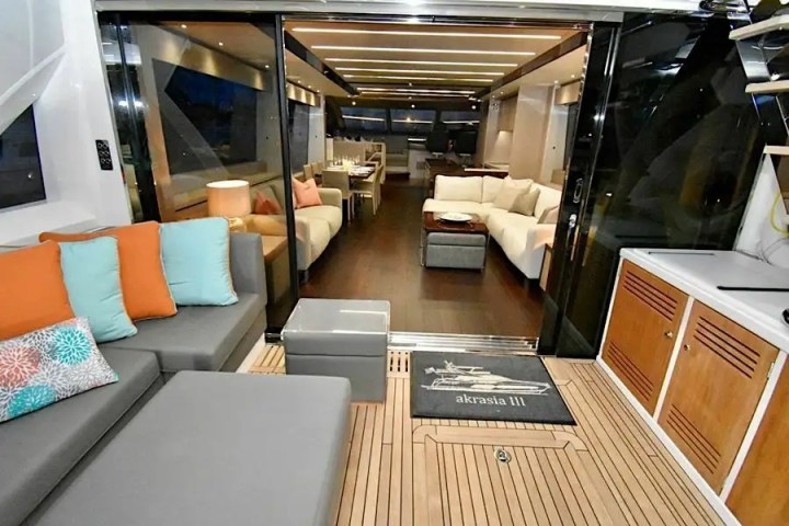 Luxury yacht interior with modern seating, colorful pillows, and ambient lighting.