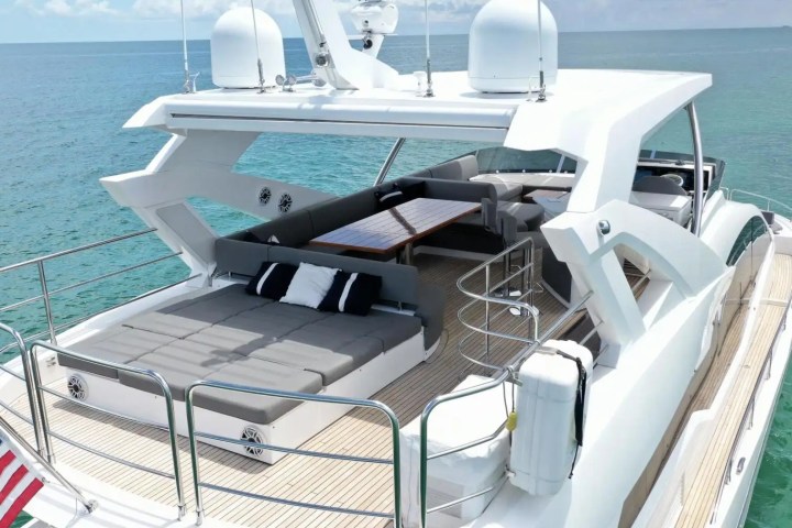 Luxury yacht deck with seating area, cushions, and ocean view.