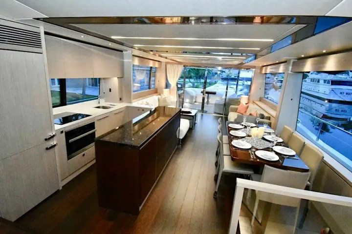 Luxurious yacht interior with kitchen, dining area, and large windows.