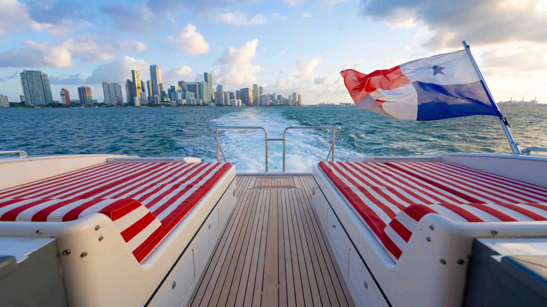 84' Mangusta yacht charter aft sun pads Miami Beach skyline Biscayne Bay