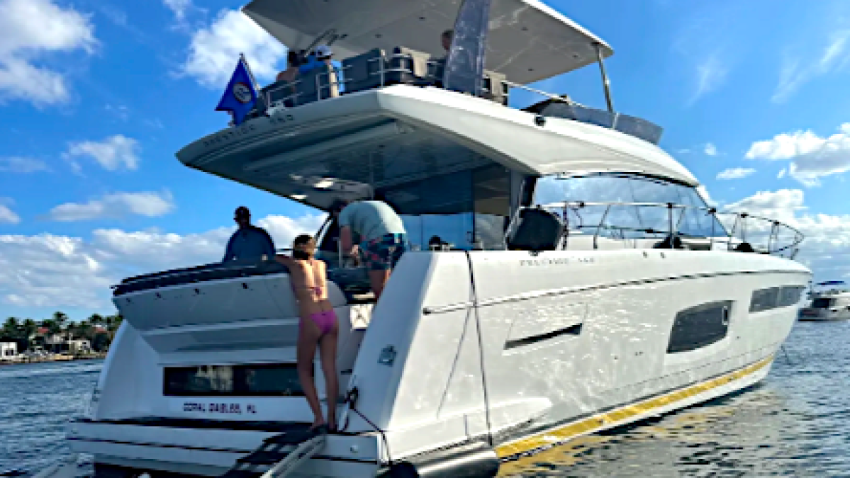 People on a yacht in sunny waters, with a ladder extending into the sea.