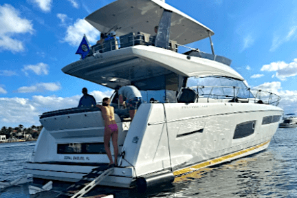People on a yacht in sunny waters, with a ladder extending into the sea.
