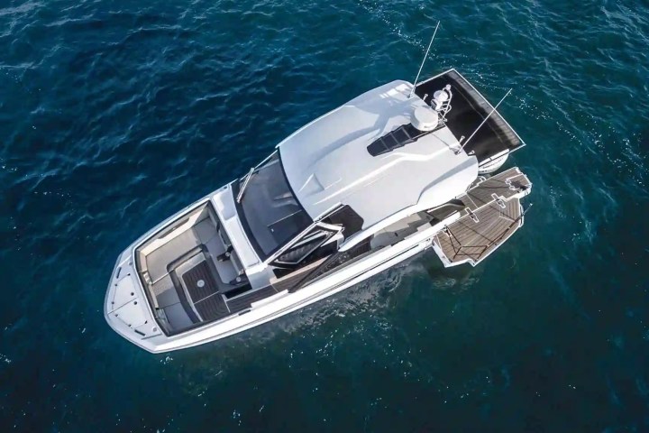 Aerial view of a white luxury yacht on blue ocean water.