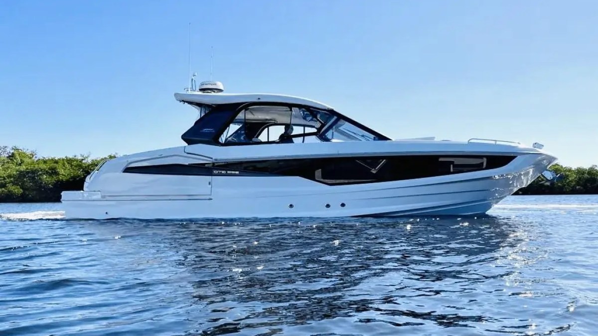 White luxury boat on calm water with clear blue sky background.