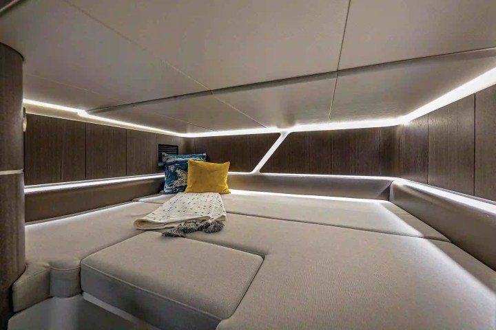 Boat cabin with gray seating, accent pillows, and soft lighting.