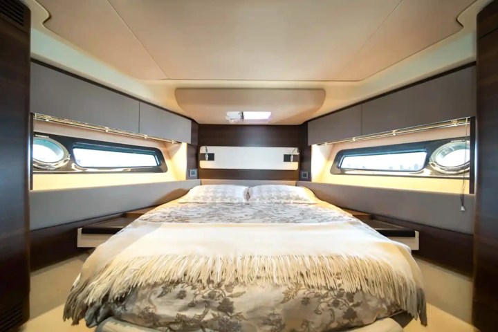Luxurious boat cabin with a double bed, windows, and modern decor.