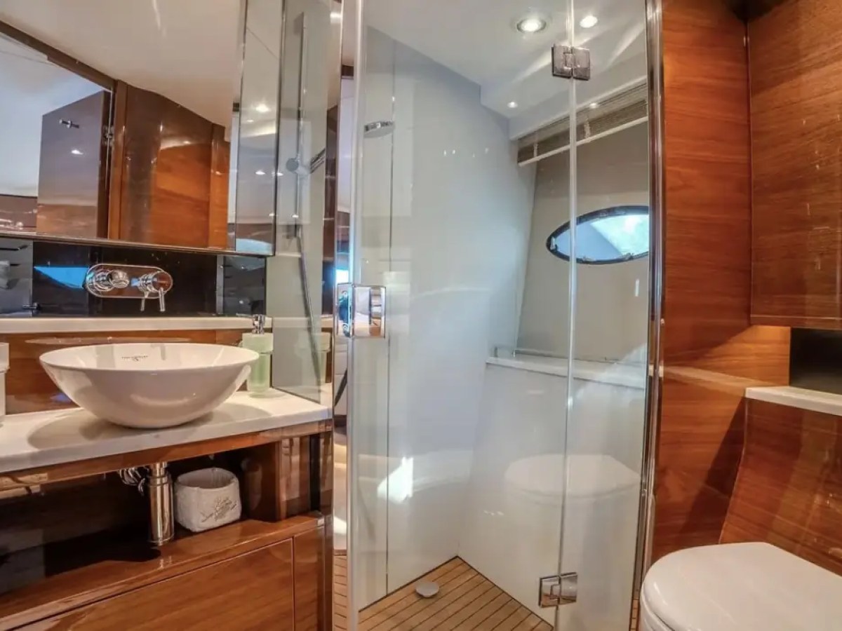 Modern bathroom with a vessel sink, glass shower, and wood accents.